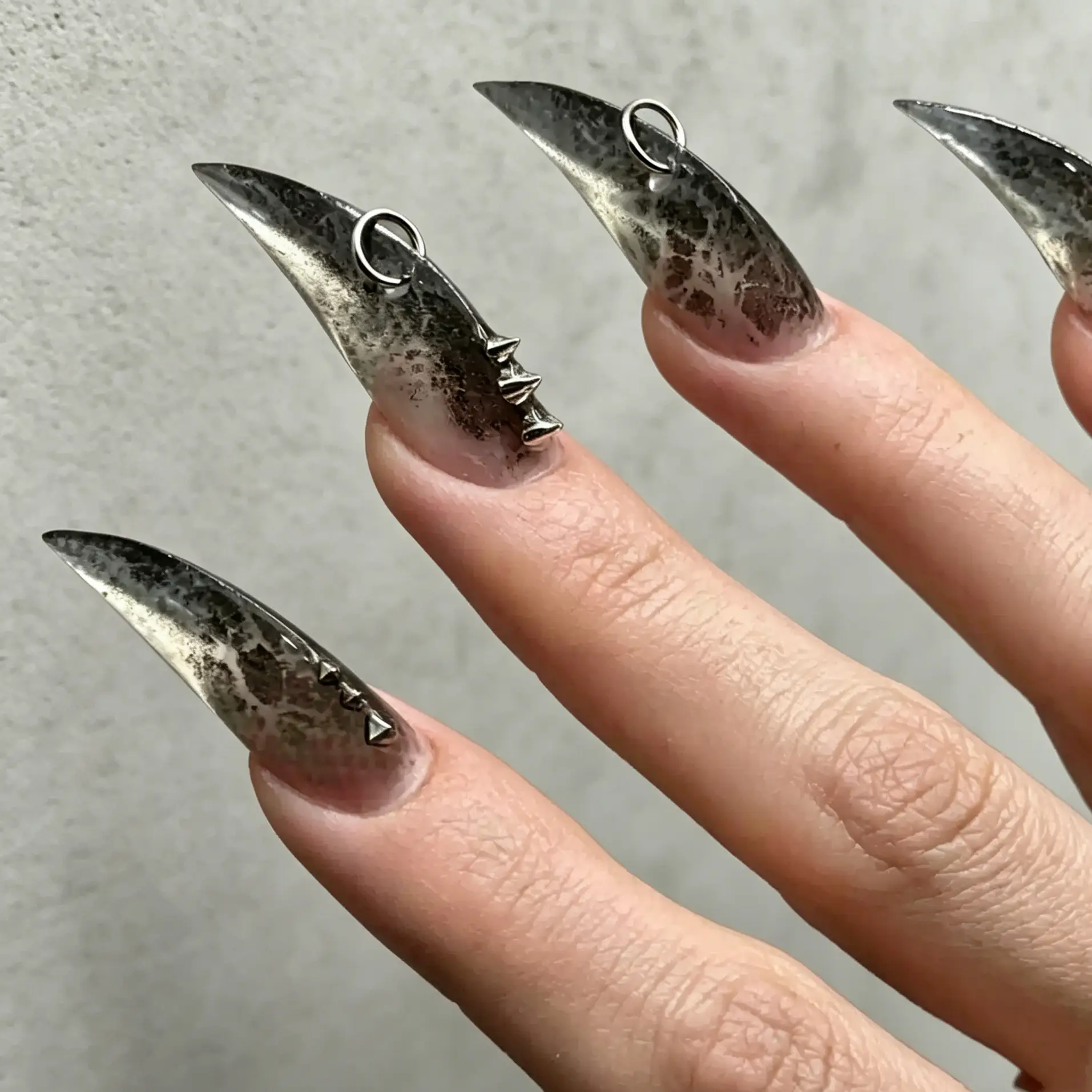 Minimal background smoky gradient speckled stiletto fake nails with metal hoop charms, dark goth punk wearable claw press on nails