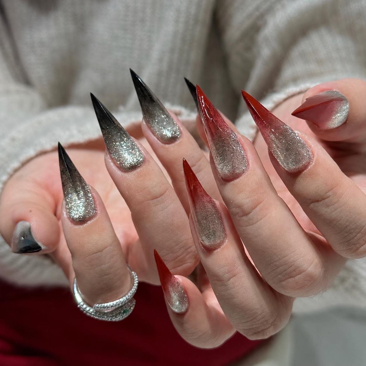 Overhead view of hands wearing red silver ombre stiletto press on nails