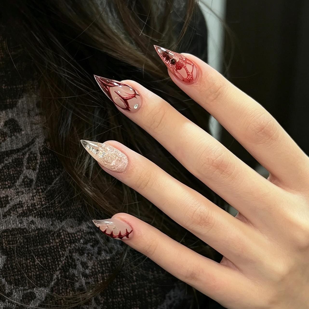 Long almond-shaped gothic press-on nails in red and black on hand