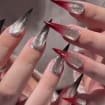 Close-up shot of hands with red silver ombre stiletto press on nails