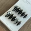 Flat lay handmade black silver graffiti stiletto press on nail set on white display sheet