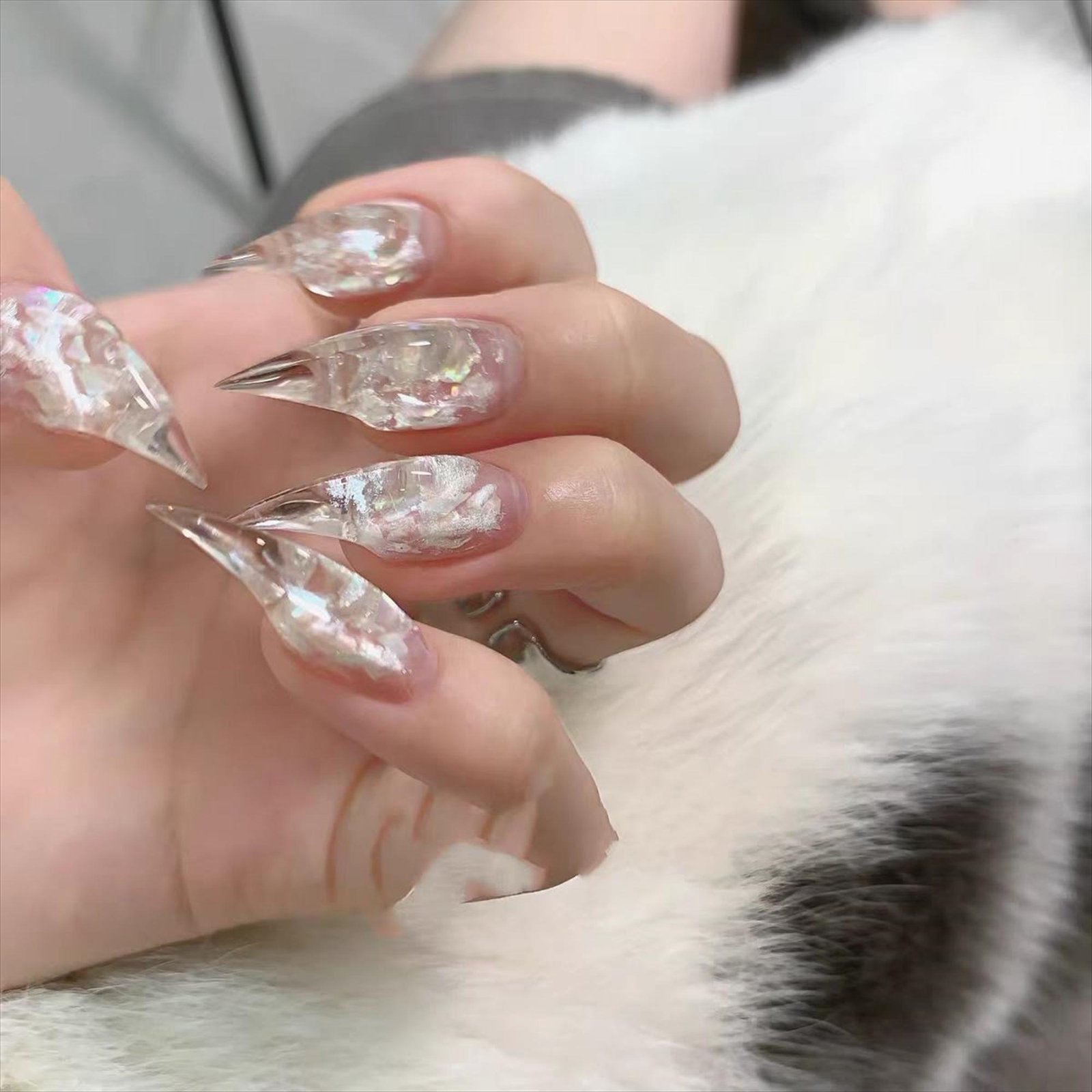 Close-up of elegant clear crystal press-on nails with sparkling nail decorations