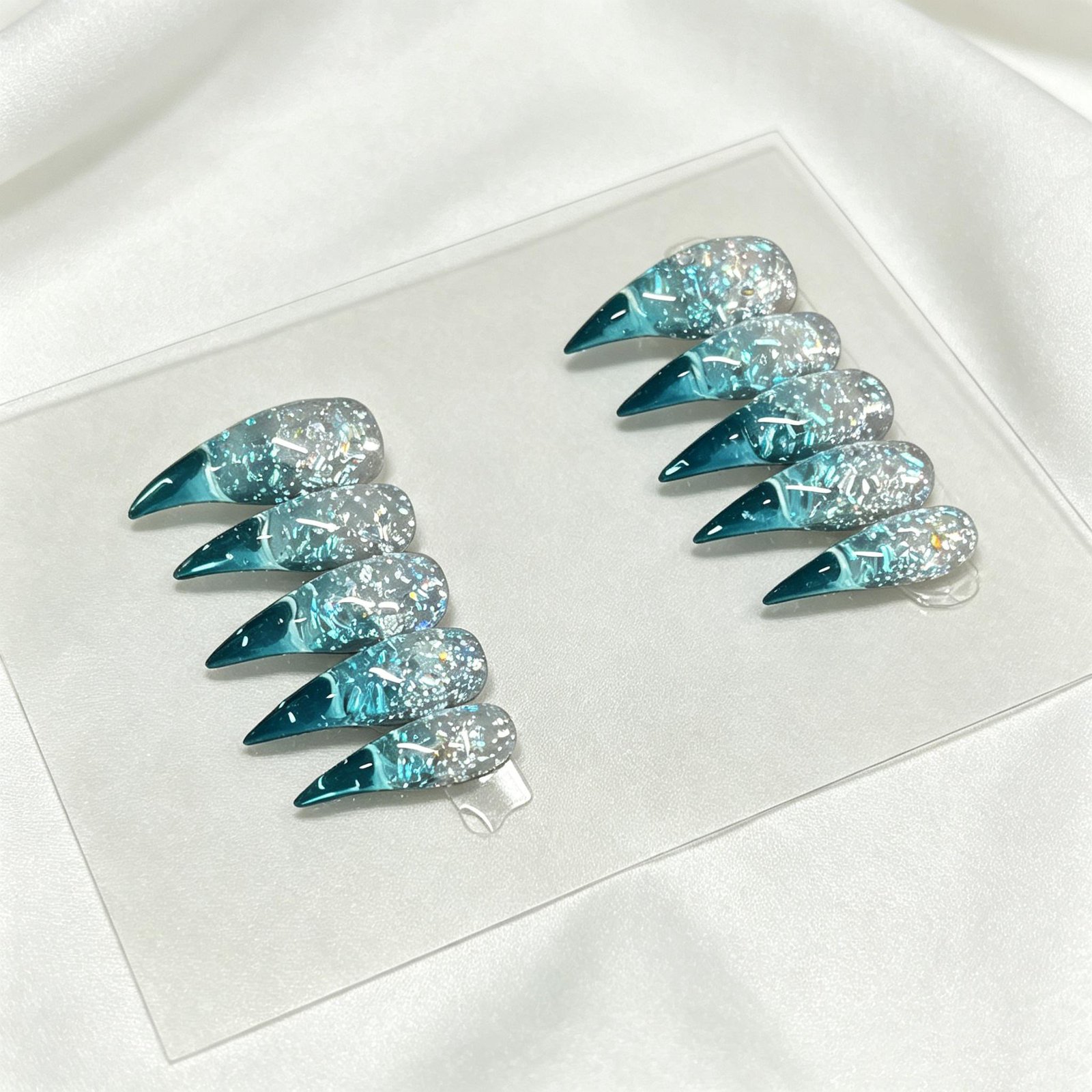 Ocean blue marble foil stiletto press on false nails separated on white silk surface