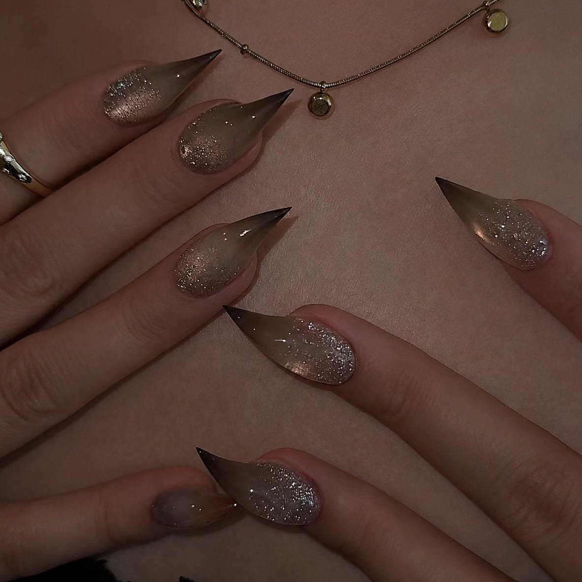Full-hand display of nude almond press-on nails with champagne shimmer