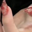 Macro view of red floral accent on luxury press-on nails