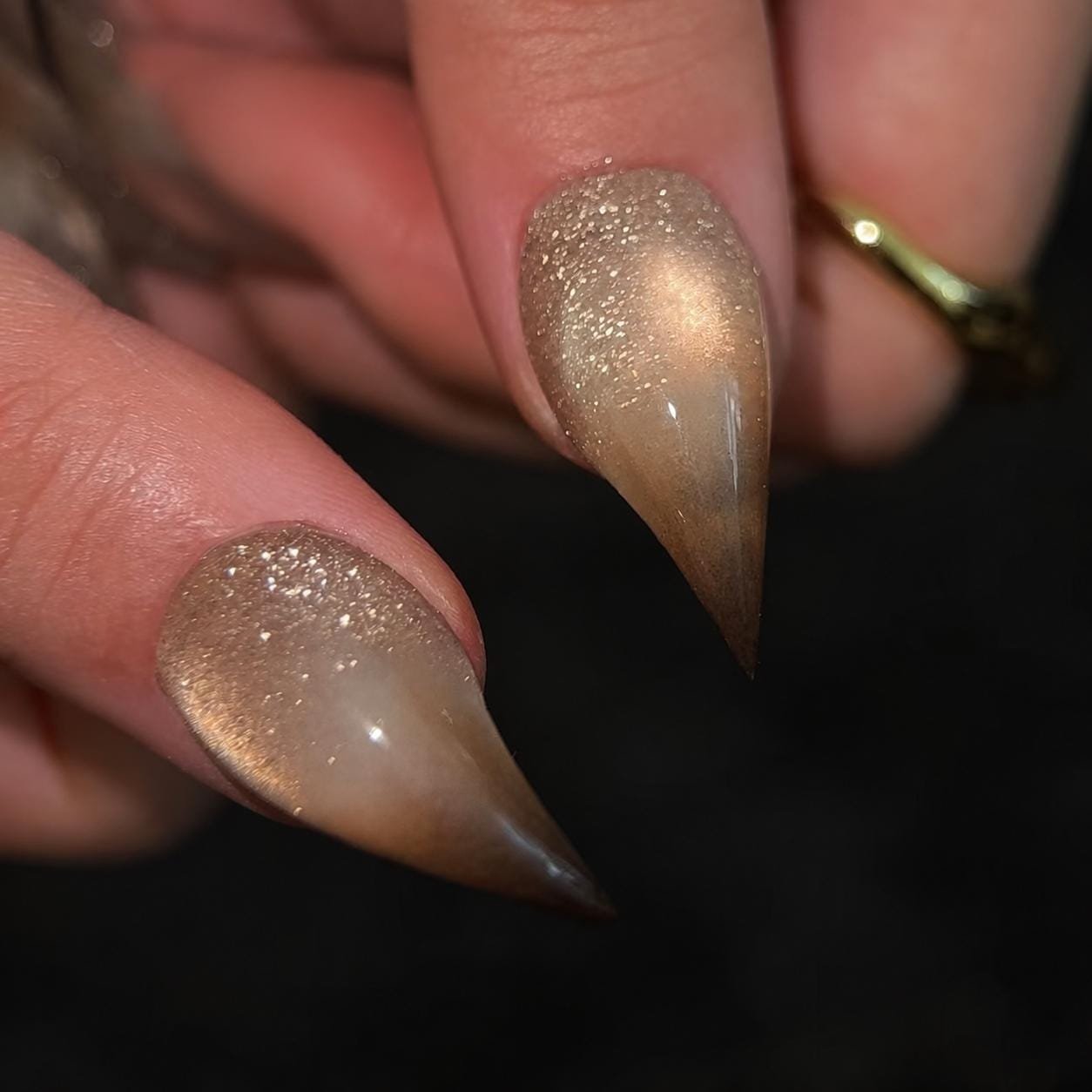 Close-up of glossy nude champagne glitter almond press-on nails