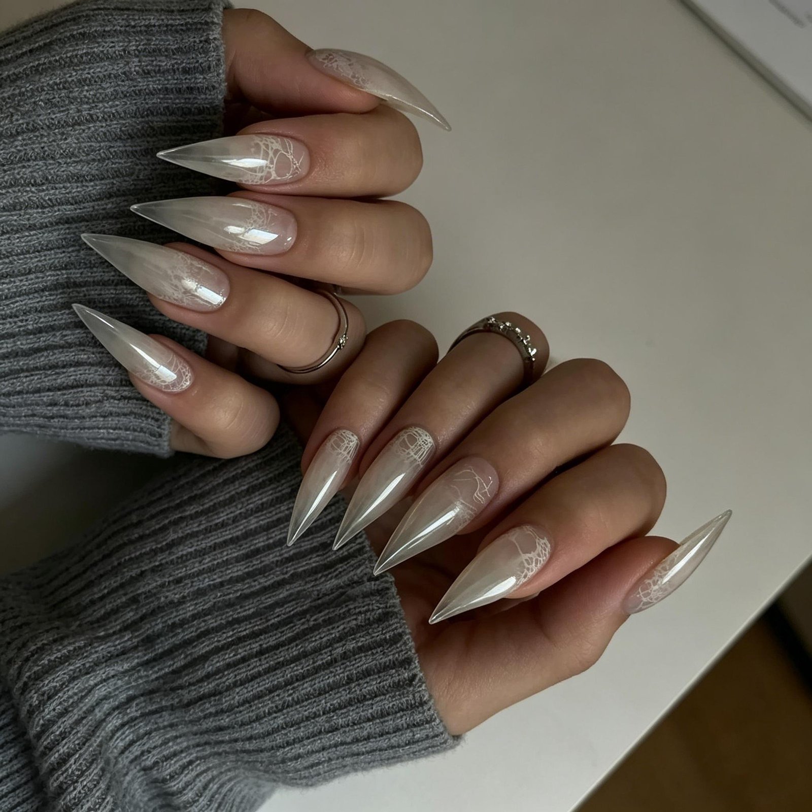 Long white metallic stiletto press-on nails with glossy chrome finish on hand