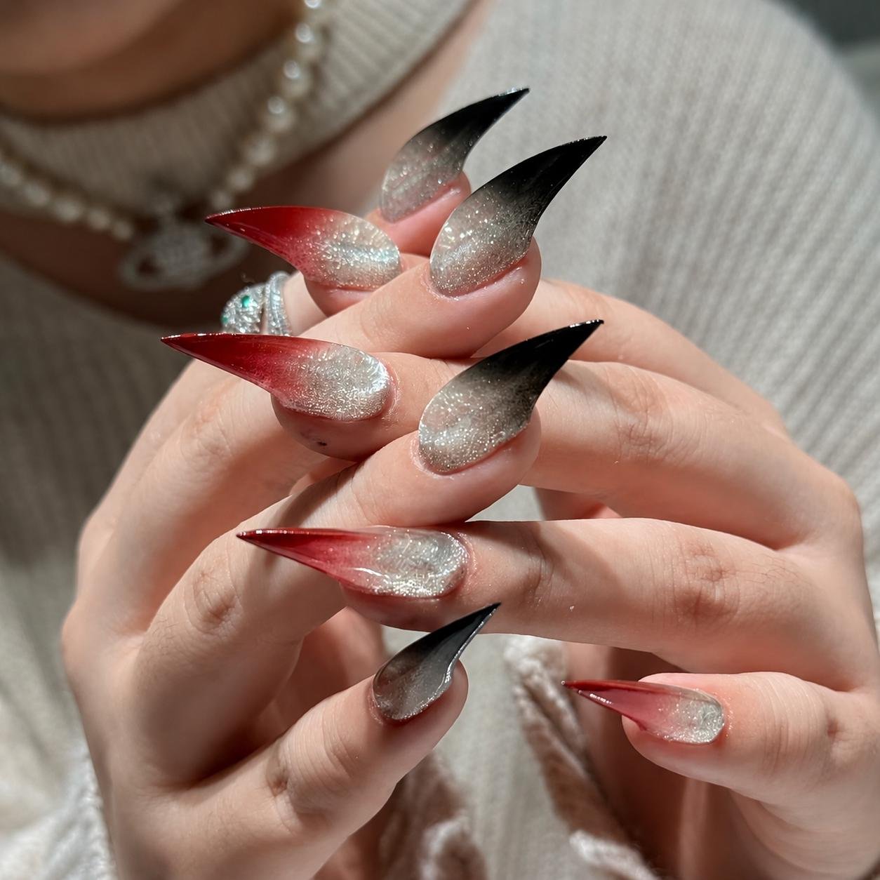 Hands wearing handmade red silver gradient stiletto press on false nails