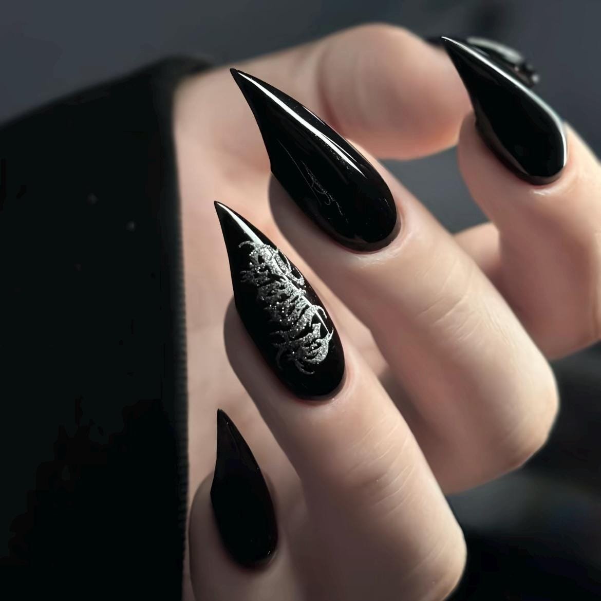 Model hand wearing plain glossy black long stiletto press on false nails